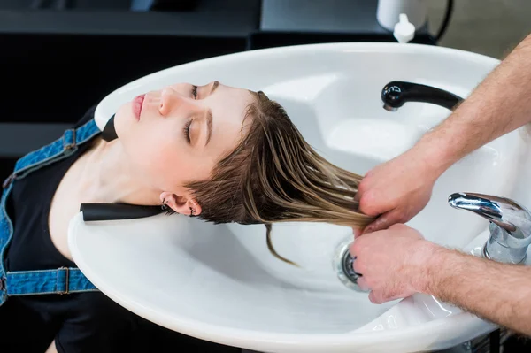 Portrait of female teen client girl getting hair wash at beauty salon. Top view. — Stock Photo, Image