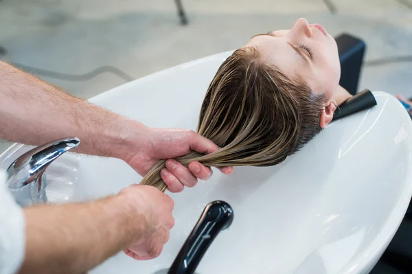 Perawatan rambut di salon spa modern. Penata rambut pria mencuci rambut gadis remaja — Stok Foto