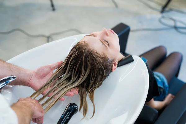 Mulher bonita recebendo uma lavagem de cabelo no salão de beleza — Fotografia de Stock