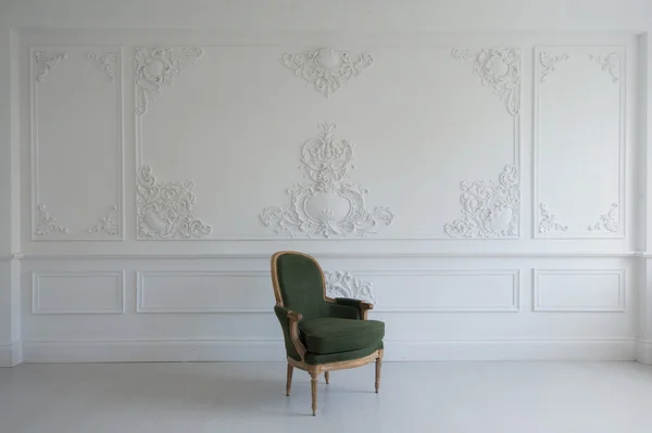 Fauteuil vintage de luxe vert dans une pièce blanche au-dessus de moulures murales en stuc bas-relief éléments roccoco — Photo