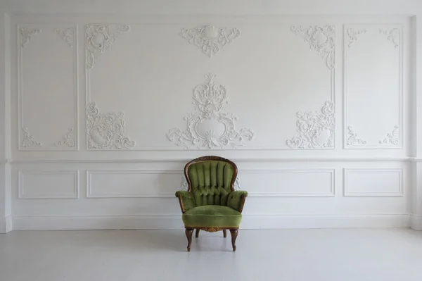 Soggiorno con antica elegante poltrona verde su lussuosa parete bianca design bassorilievo modanature in stucco elementi roccocò — Foto Stock