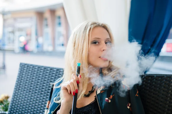 Beautiful young blonde woman smoking hookah at outdoors cafe — Stock Photo, Image
