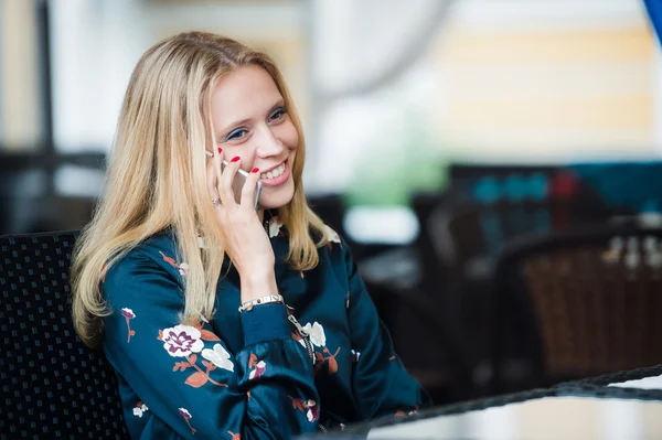 Imagen franca de una joven hablando por teléfono en un café. Enfoque selectivo . — Foto de Stock