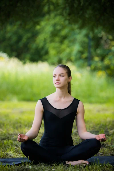 Красива молода дівчина медитує в літньому парку — стокове фото