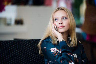 Genç kadın bir kafede telefonda konuşuyor. Seçici odak.