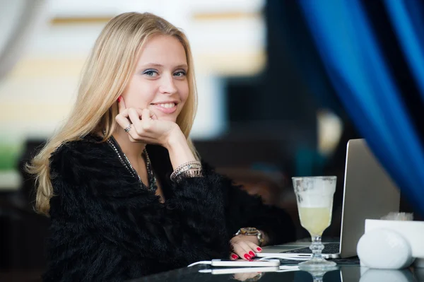 Joven hermosa mujer europea con cara bonita pensando en algo mientras está sentado con el ordenador portátil en el bar de la cafetería, soñadora hermosa mujer usando el net-book portátil durante el descanso de trabajo en la cafetería — Foto de Stock