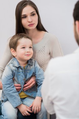 Tablet pc inceleyerek çocuk ve annesi danışmanlık çocuk doktoru doktor tutar.