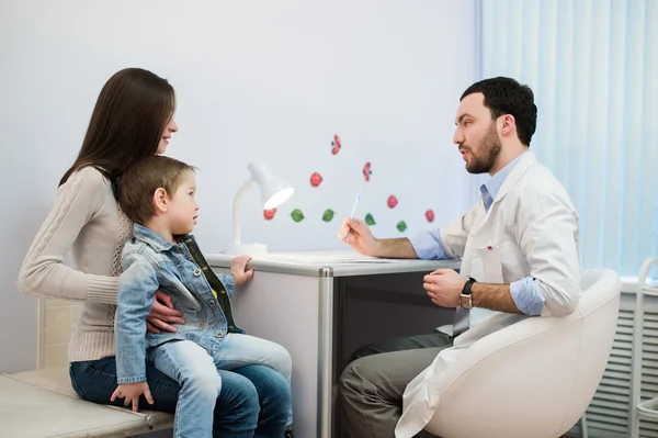 Pediatra hablando con madre e hijo en el consultorio — Foto de Stock