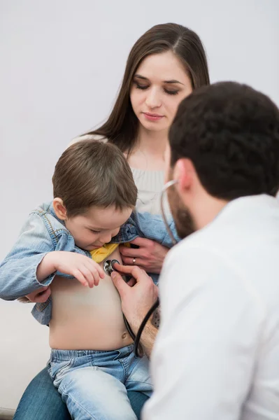 Pediatr doktor vyšetřují dítě chlapec. Matka dítě hospodářství. — Stock fotografie