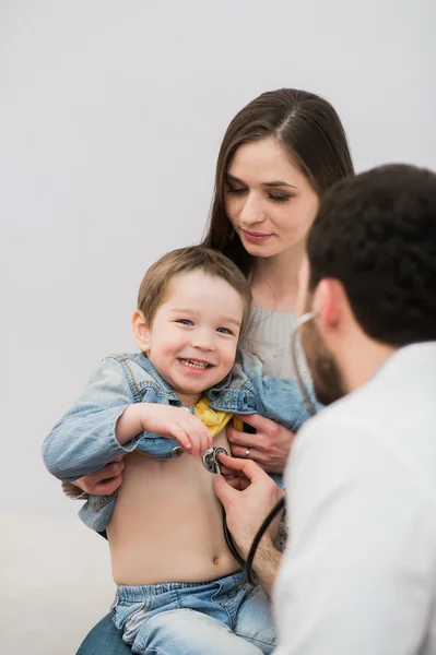 Pediatr doktor vyšetřující šťastné dítě chlapec. Matka dítě hospodářství. — Stock fotografie