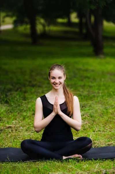 Portrait of smiling beautiful sporty young woman working out in park alley, standing with palms touching in Namaste gesture — Stock Photo, Image