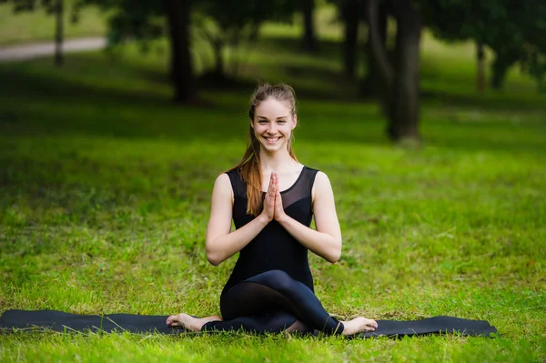 Портрет посміхаючись красиві спортивний молода жінка тренування в алеї парку, стоячи з долоні, торкаючись Namaste жест — стокове фото