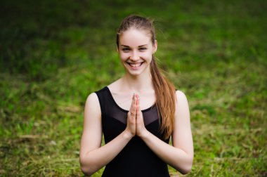 Açık havada kopya alanı ile yeşil çim üzerinde bir parkta pratik genç yoga öğretmeni