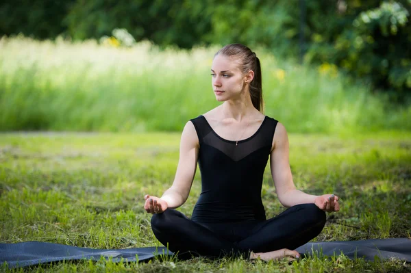 Beautiful young girl meditating in summer park — Stock Photo, Image