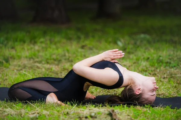 Fiatal nő, jóga, fekvő pozícióban gerinc twist — Stock Fotó