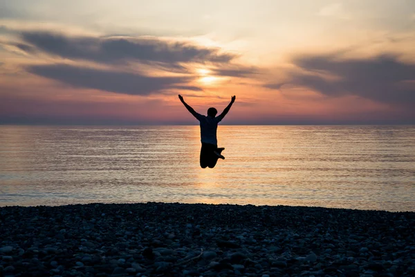 Силуэт человека счастья на пляже восхода солнца — стоковое фото