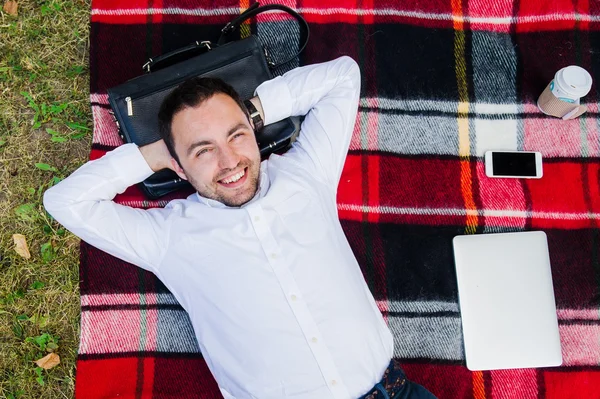 Happy young man with laptop relaxing on the grass, view from the top — Stock Photo, Image