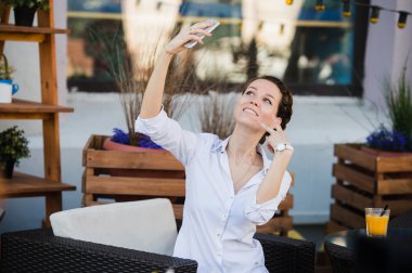 Selfie taze portakal suyu ile öğle yemeğine için bekleme sırasında açık havada café'de alarak iş kadını