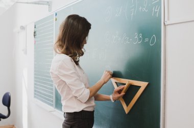 Zeki öğrenci ya da öğretmen matematik formülü tahta, üniversite üniforma giymiş, çizim tebeşir - formüller ve çizim karalanmış. Akıllı kavramı ve bilim adamı kadın