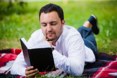 yakışıklı genç işadamı parkta yalan kitap okuma