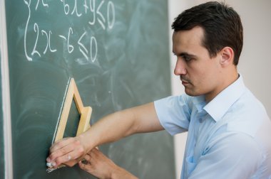 Genç öğretmen veya öğrenci formülü ile bir kara tahta üzerinde üçgen çizmek