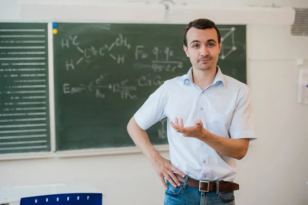 Jeune enseignant près de tableau dans la classe scolaire parler à la classe — Photo