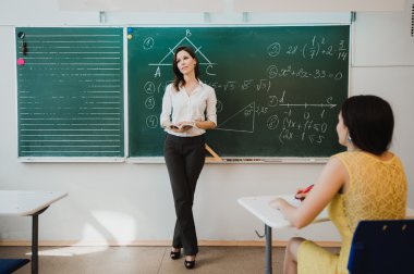 Öğretmen veya docent ya da iken bir karatahta önünde derse ya da bir parça kağıt kurulu ve eğitmek veren eğitimci veya öğrenci veya öğrenci veya okuldaki veya sınıf arkadaşları öğretim