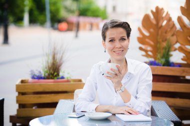 Güzel iş kadını gülümseme ile eğlence süre boyunca rahat restoranda dokunmatik yüzey ile oturuyor, mutlu kız öğrenci kafede Üniversitesi sonra rahatlatır.