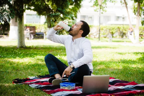 Businessman working in the garden and eating lunch — Stock Photo, Image