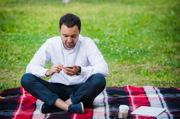 Joven hombre de negocios en el parque trabajando con la tableta — Foto de Stock