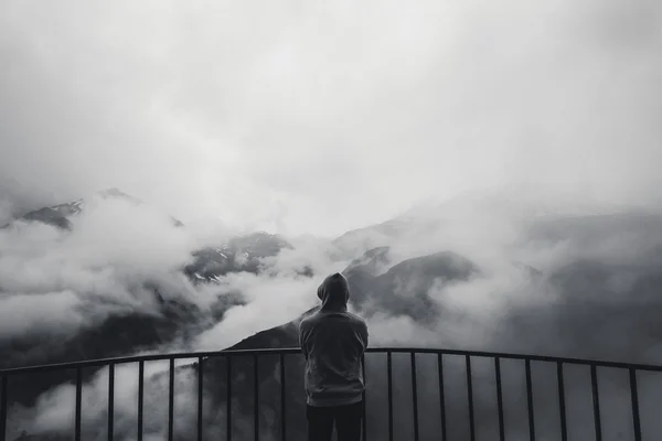 Landschaft Blick auf neblige Herbst Berghügel mit Nebel und Mann Silhouette in einer Kapuze bedeckt. Monochromes Foto — Stockfoto