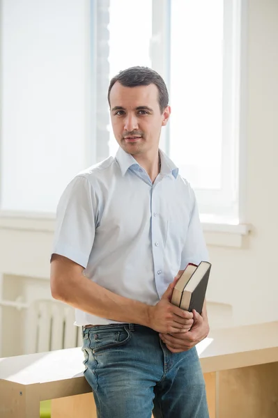 Portret van de jonge man houden van boeken, kijken naar camera — Stockfoto