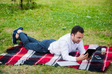 yakışıklı genç işadamı parkta yalan kitap okuma