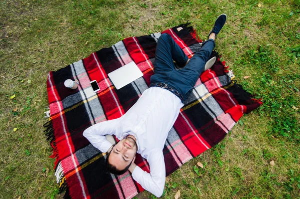 Feliz joven con portátil relajante en la hierba, vista desde la parte superior — Foto de Stock