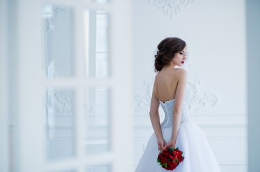 Çiçekler buket ışık Oda kapıları yanında, onun elinde güzel bir gelinle moda fotoğrafı
