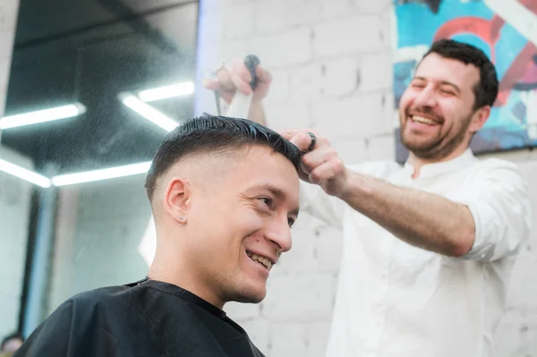 Masculino barbeiro dando cliente corte de cabelo na loja — Fotografia de Stock