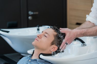 Genç bir adam onun saç güzellik salonunda yıkanmış olması Close-Up