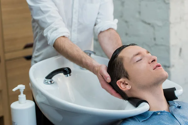 Профиль молодого человека, готовящегося к мытью волос — стоковое фото
