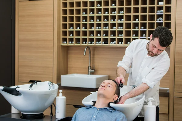 Close-up of a young man having his hair washed in hairdressing salon — Stock Photo, Image