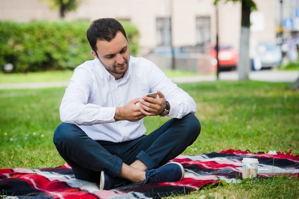 Joven hombre de negocios en el parque trabajando con la tableta — Foto de Stock