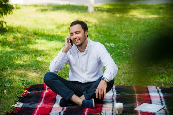 Joven hombre de negocios en el parque trabajando con la tableta — Foto de Stock