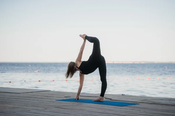 Immagine di una bella donna che fa yoga al lago — Foto Stock