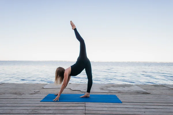 Image of a pretty woman doing yoga at the lake — Stock Photo, Image