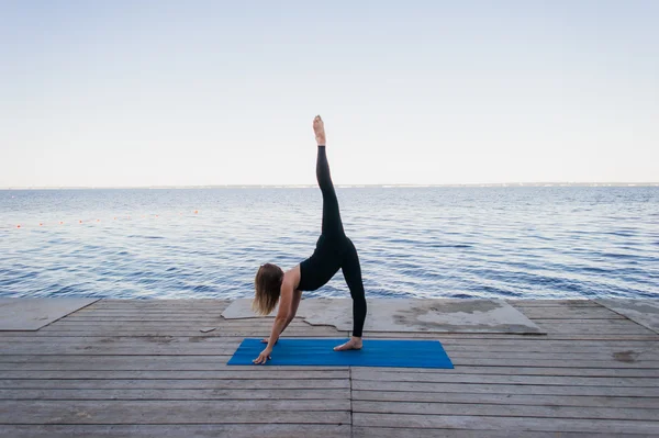 Immagine di una bella donna che fa yoga al lago — Foto Stock