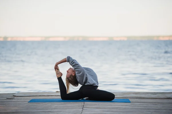 Young sport woman practicing yoga on the beach — Stock Photo, Image