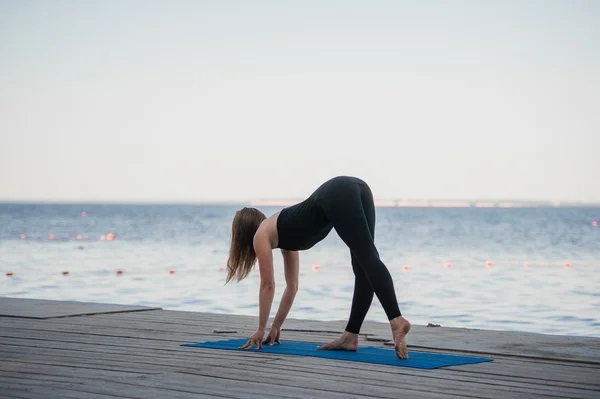 Image of a pretty woman doing yoga at the lake — Stock Photo, Image