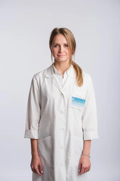 Enfermera o médico joven de pie y mirando a la cámara. Aislado sobre fondo blanco . — Foto de Stock