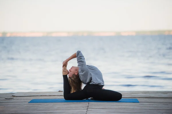 Young sport woman practicing yoga on the beach — Stock Photo, Image