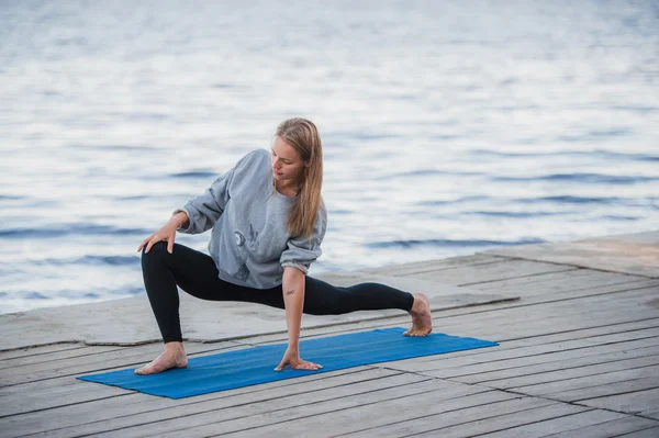 Молодая спортсменка практикует йогу на пляже — стоковое фото