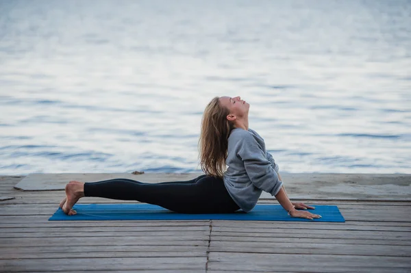 Giovane donna sportiva che pratica yoga sulla spiaggia — Foto Stock